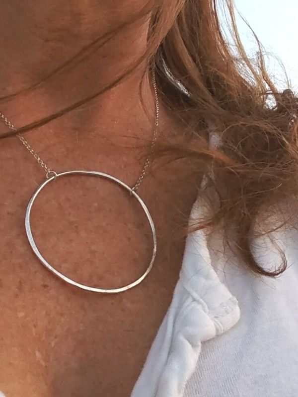 wearing big silver open circle necklace