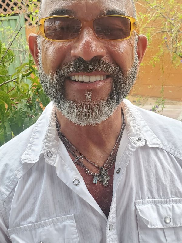 man wearing three silver necklaces