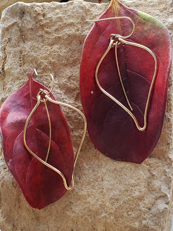 gold wire leaf earrings on red leaves