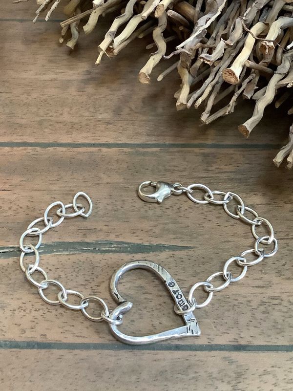 handcrafted silver heart chain bracelet on wood