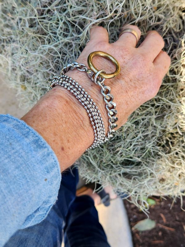 hearty silver chain layered bracelets on wrist