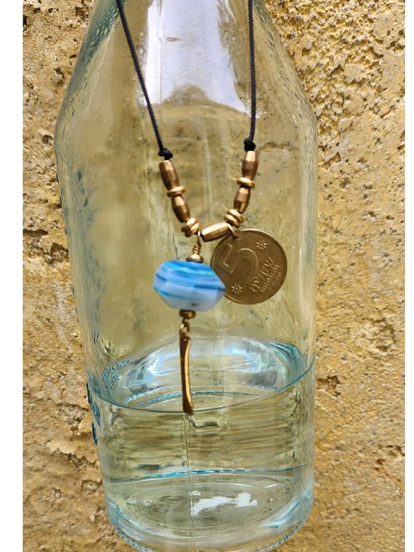 old coin gemstone necklace displayed on glass vase