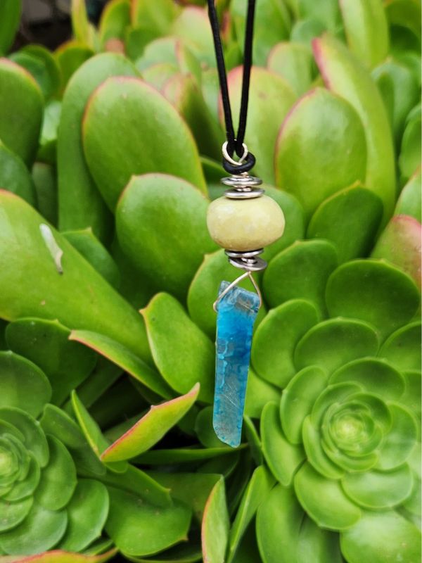 green gemstone stick necklace and green plants