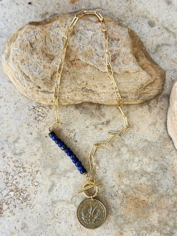 old coin gold chain blue gemstone necklace on stones