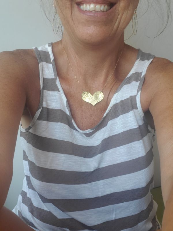 textured gold heart chain necklace on model with striped top
