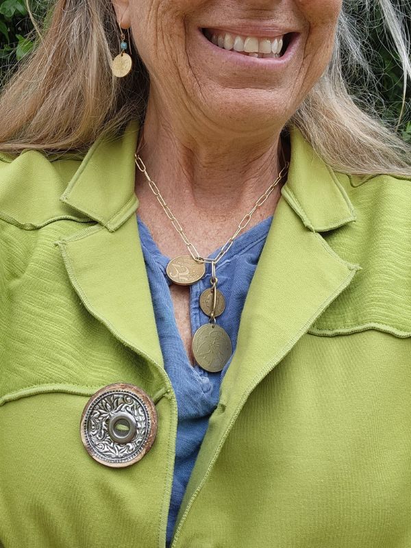 wearing gold coin jewelry and green jacket