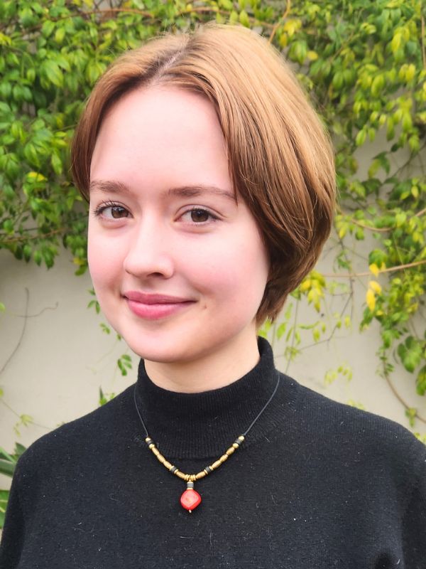 model wearing red coral necklace and black turtleneck top