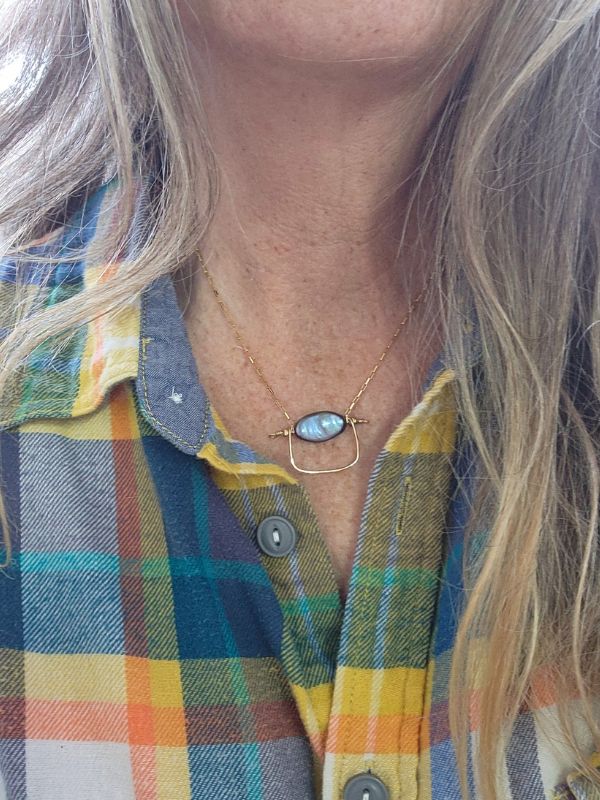 model wearing pearl necklace flannel shirt and earrings