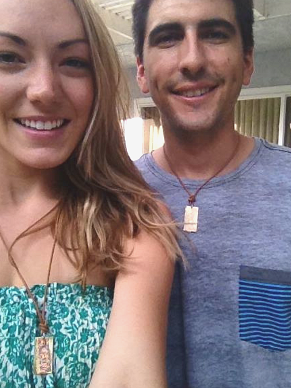 Newlyweds showing off their wedding necklaces