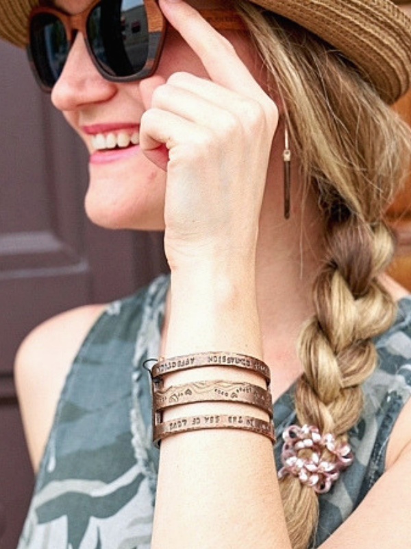 copper cuff on arms of female wearing hat