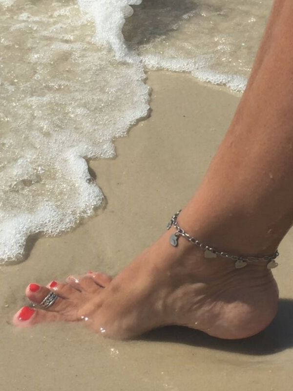 anklet on foot with red toe nails in the ocean