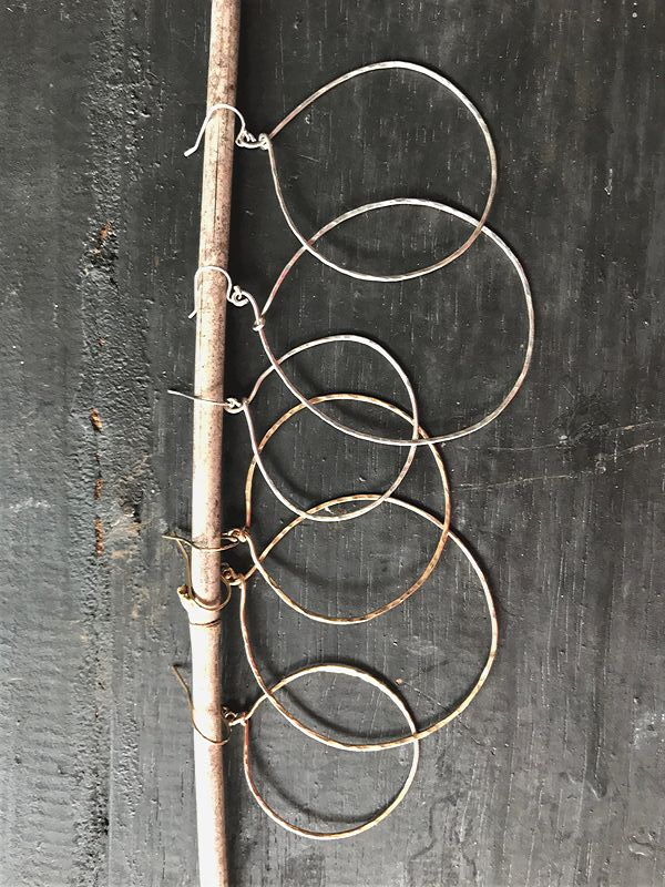 series of hoop earrings on black wood