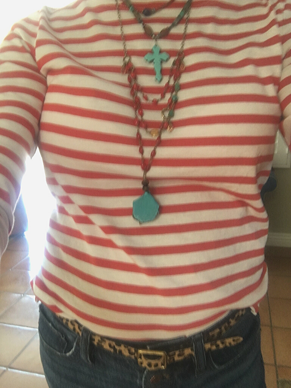 layers of long boho beaded necklace worn with red striped top