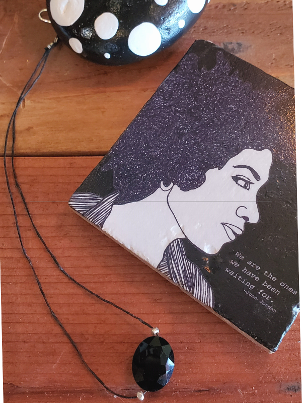 black coaster, necklace and a rock