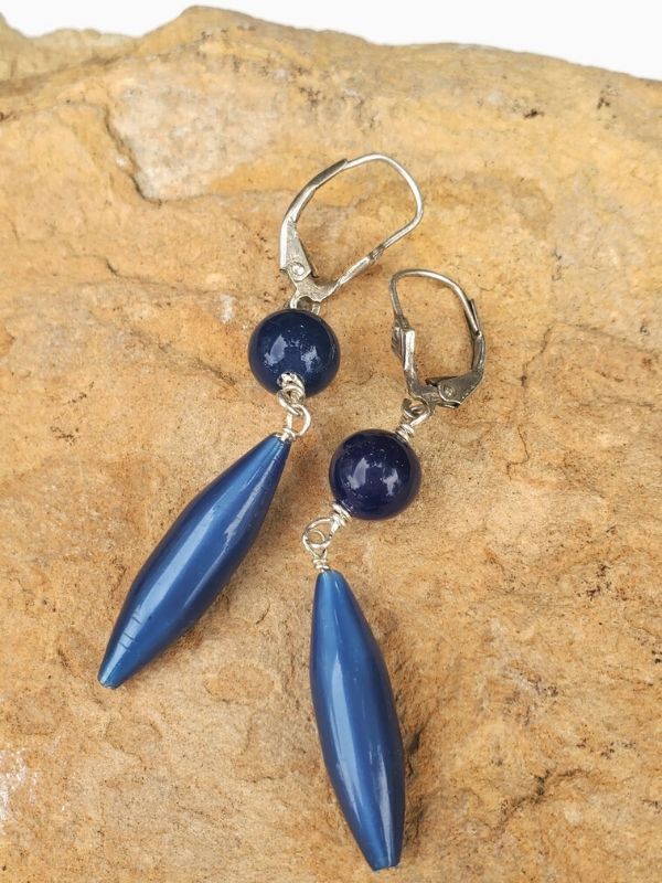 blue earrings on brown rock