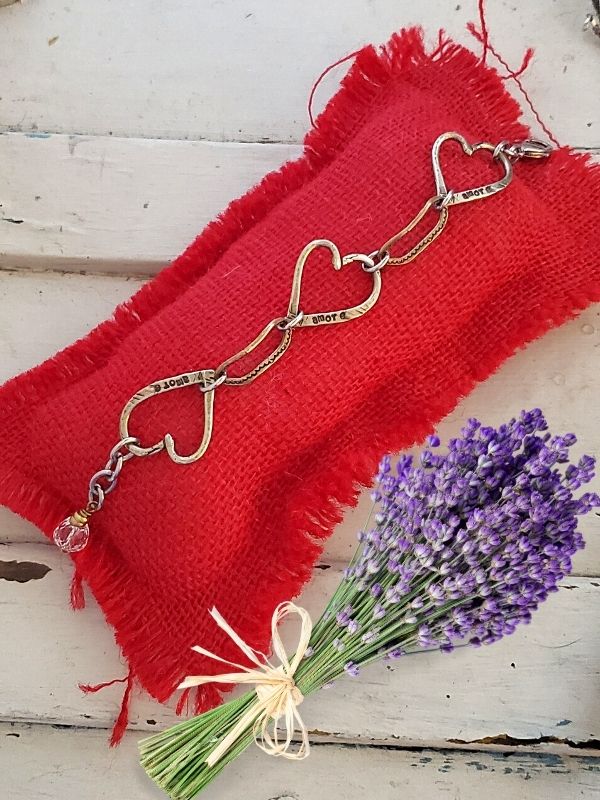 heart bracelet on red pillow with flowers